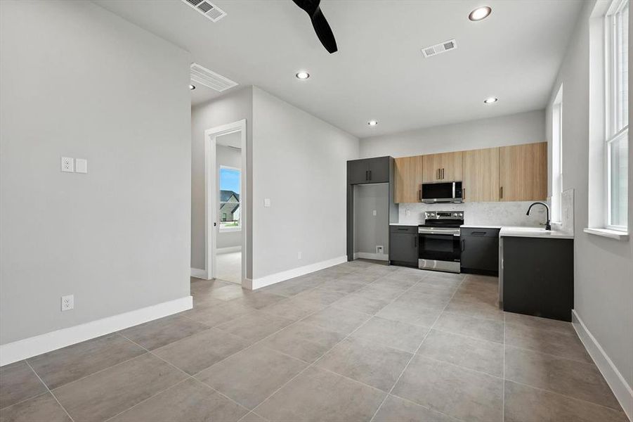Kitchen with stainless steel appliances, light countertops, ceiling fan, recessed lighting, and light tile patterned flooring