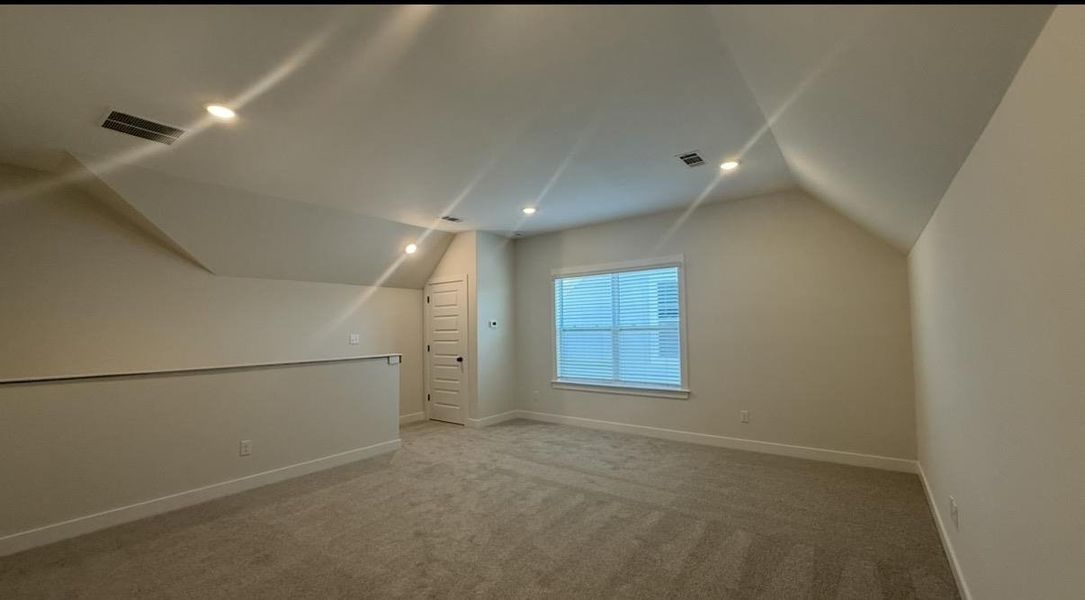 Bonus room with carpet floors and recessed lighting