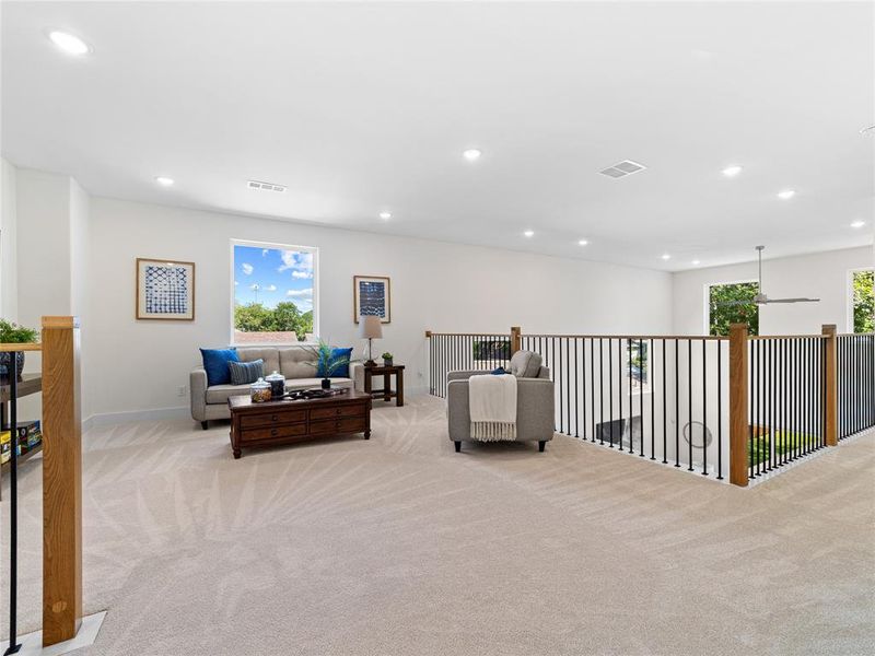 Sitting room with light carpet and recessed lighting