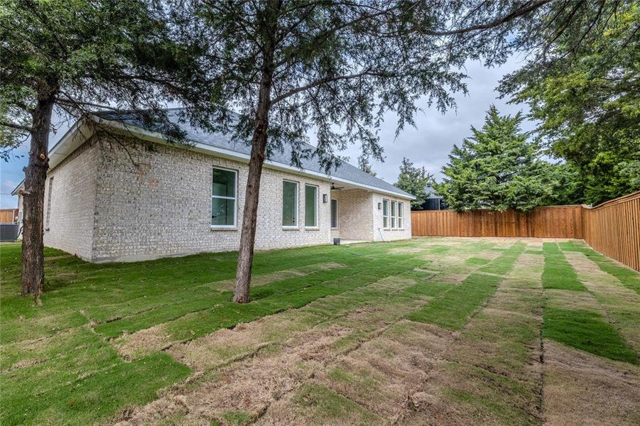 Back of property with brick siding, a patio, and a fenced backyard