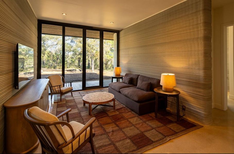 Living room featuring a wall of windows and finished concrete flooring