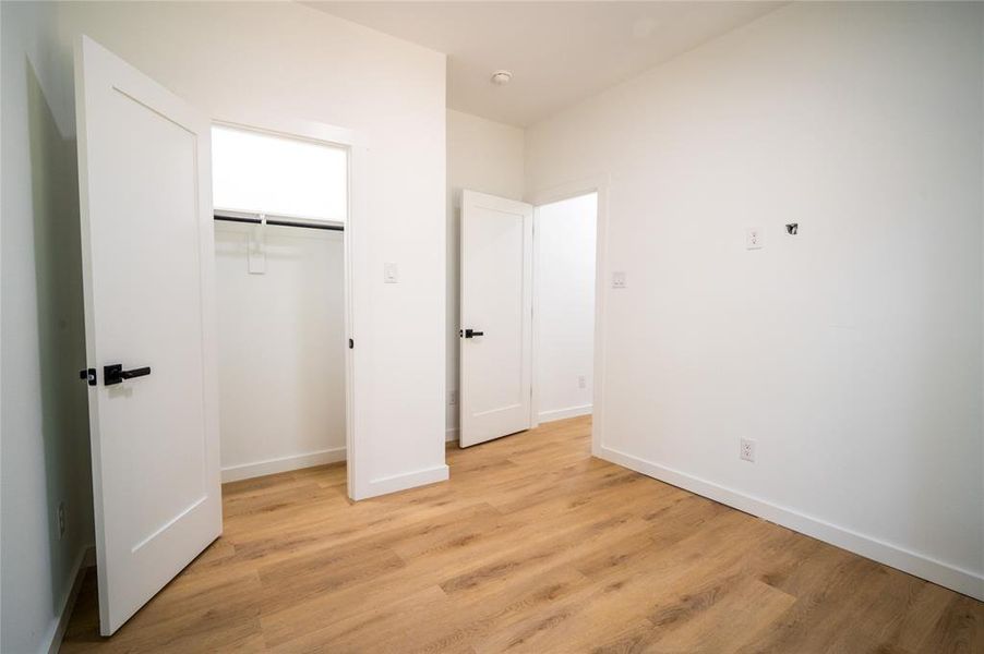 Unfurnished bedroom featuring a closet and light hardwood / wood-style floors