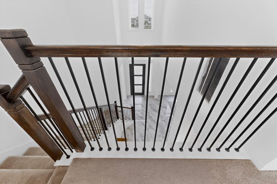 Staircase featuring dark wood handrails and balusters with black metal spindles