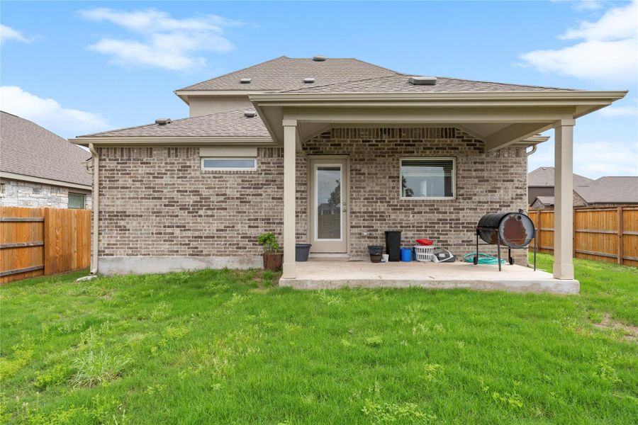 Rear view of property featuring a patio, brick siding, and roof with shingles Rear view of property featuring a patio, brick siding, and roof with shingles