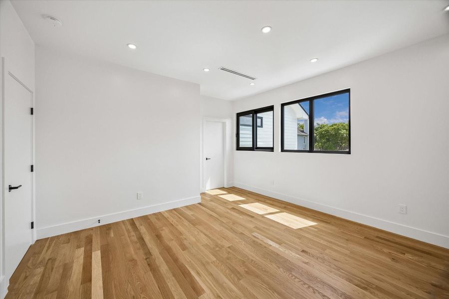 Bright and spacious room with sleek hardwood floors, recessed lighting, and large windows offering abundant natural light. Bright and spacious room with sleek hardwood floors, recessed lighting, and large windows offering abundant natural light.