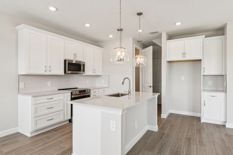 Additional cabinetry next to the refrigerator provides extra storage