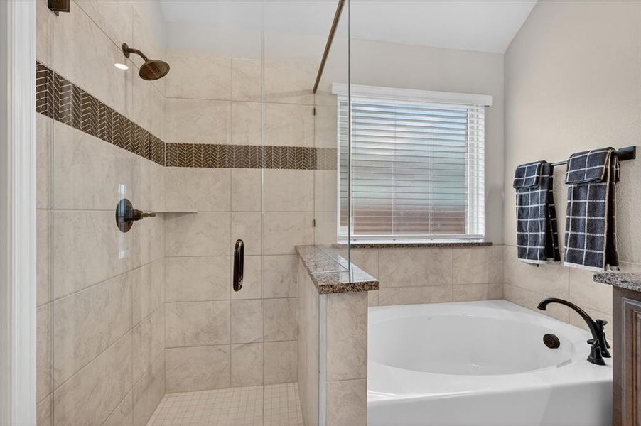 Tiled shower enclosure with glass surround, decorative accent band, and oil-rubbed bronze fixtures Tiled shower enclosure with glass surround, decorative accent band, and oil-rubbed bronze fixtures