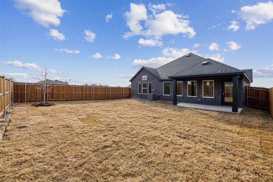 Rear view of house featuring a fenced backyard and a covered patio area