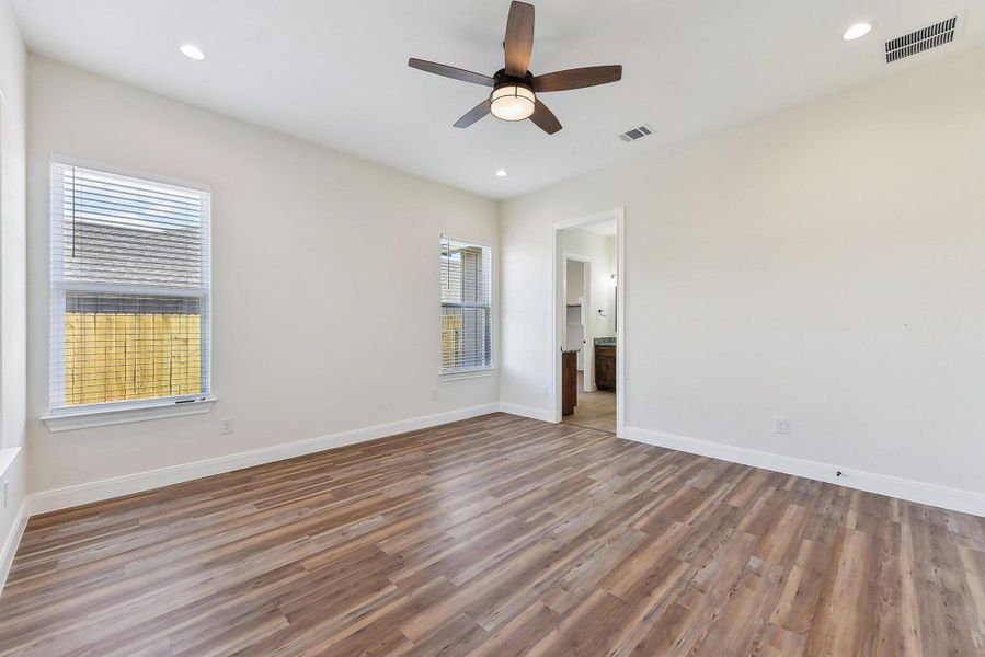 Empty room with recessed lighting, visible vents, baseboards, and wood finished floors Empty room with recessed lighting, visible vents, baseboards, and wood finished floors