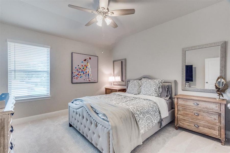 Bedroom featuring light carpet, ceiling fan, and lofted ceiling