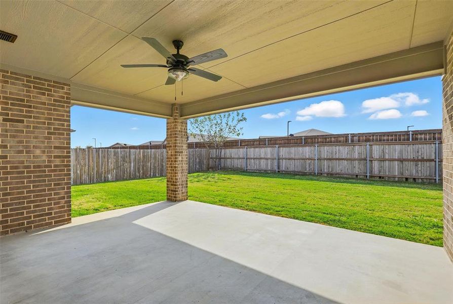 Fenced backyard featuring a ceiling fan and a patio area Fenced backyard featuring a ceiling fan and a patio area