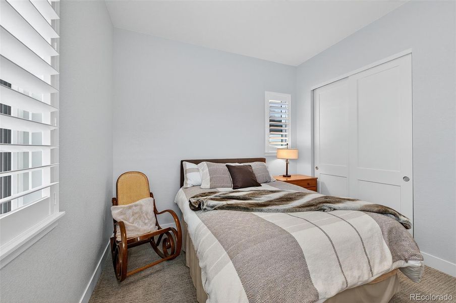 Bedroom 2 (Angle 2) – Well-sized guest or family bedroom with ample natural light and a spacious closet behind sliding doors.