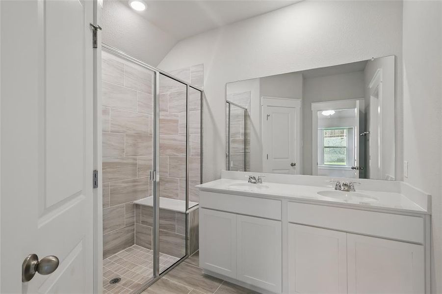 Full bath featuring a shower stall and double vanity Full bath featuring a shower stall and double vanity