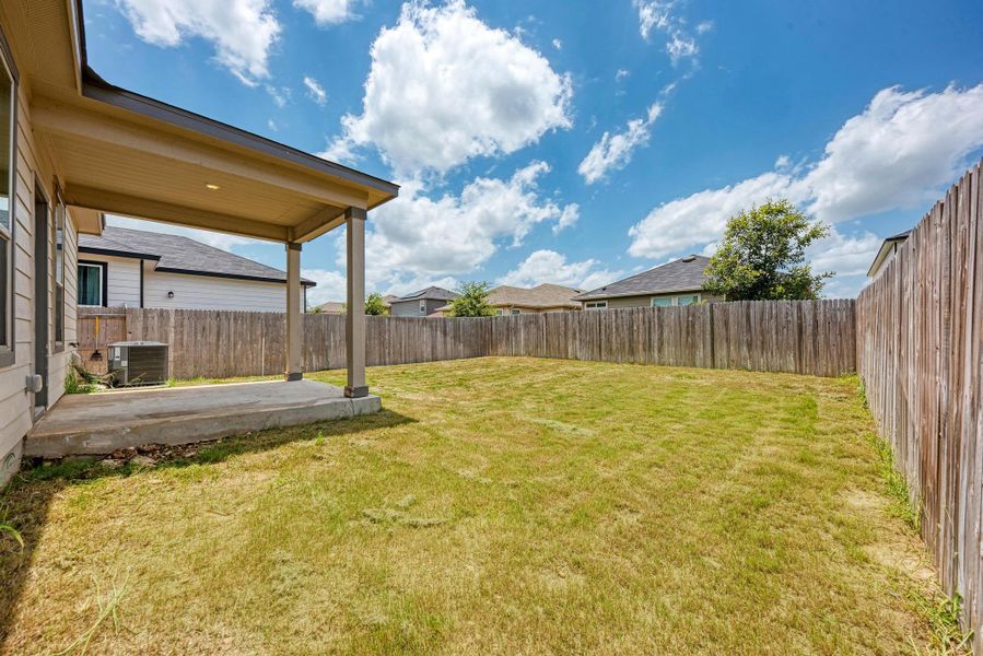A spacious backyard awaits, fully fenced for privacy, featuring a covered patio for outdoor enjoyment.