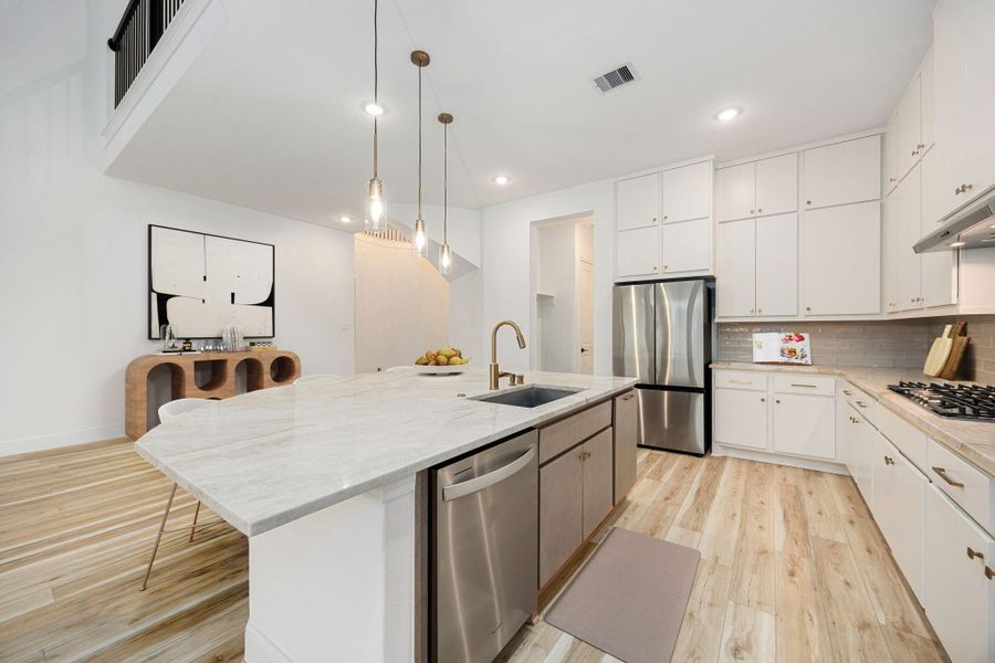 This well-designed kitchen features an expansive island, white cabinetry, and an open layout ideal for everyday use.