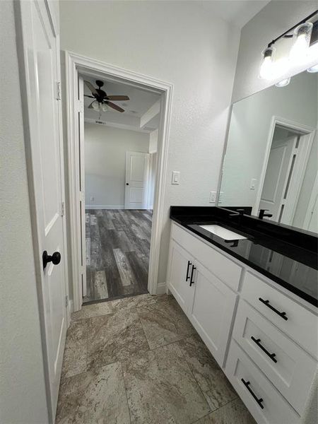 Bathroom featuring vanity, a ceiling fan, and baseboards