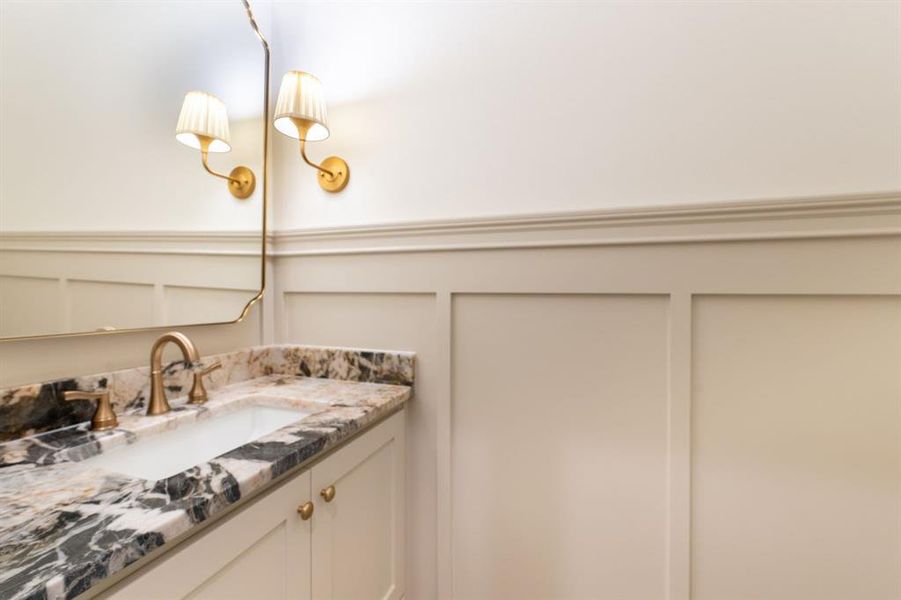 Vanity featuring a patterned stone countertop, undermount sink, and three-piece brushed gold faucet Vanity featuring a patterned stone countertop, undermount sink, and three-piece brushed gold faucet