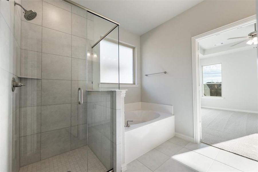 Bathroom with a bath, a shower stall, light tile patterned floors, and light colored carpet
