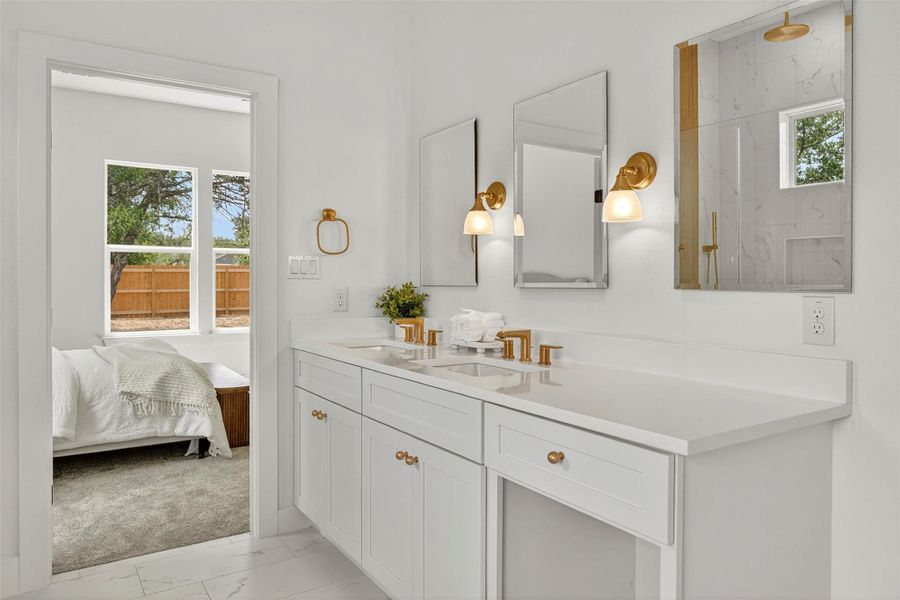 Bathroom featuring double vanity, light marble finish floors, a marble finish shower, and ensuite bath