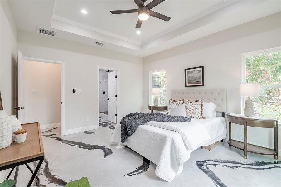 Bedroom featuring ornamental molding, multiple windows, ceiling fan, and a raised ceiling