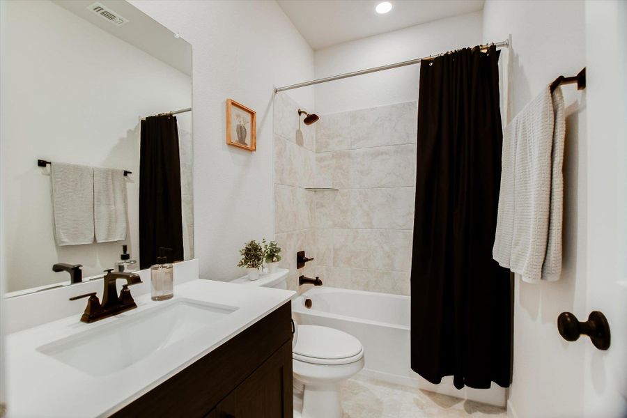 A well-appointed bathroom features a single vanity, a full bath with a shower, and soft recessed lighting. A well-appointed bathroom features a single vanity, a full bath with a shower, and soft recessed lighting.