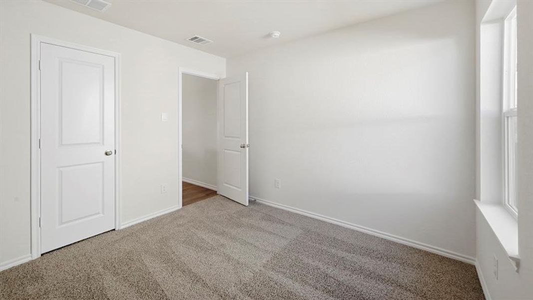 Unfurnished bedroom with carpet flooring and baseboards Unfurnished bedroom with carpet flooring and baseboards
