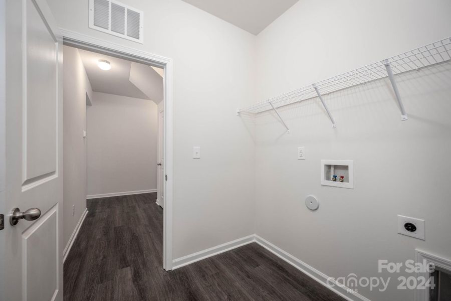 Laundry room with access to primary closet and hall