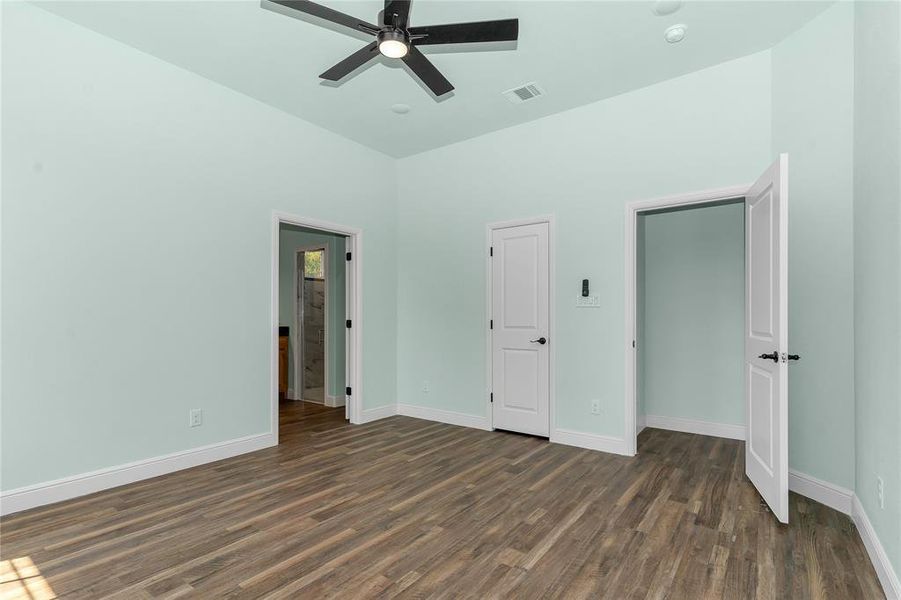 Unfurnished bedroom featuring dark wood-style floors and a ceiling fan