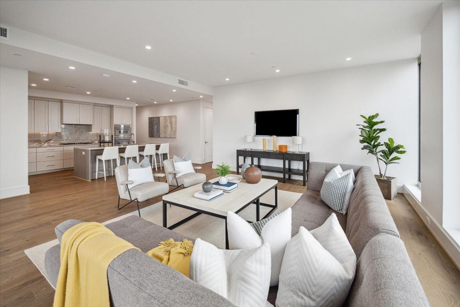 View of the kitchen from living room. Photos are of a similar unit with the same floor plan