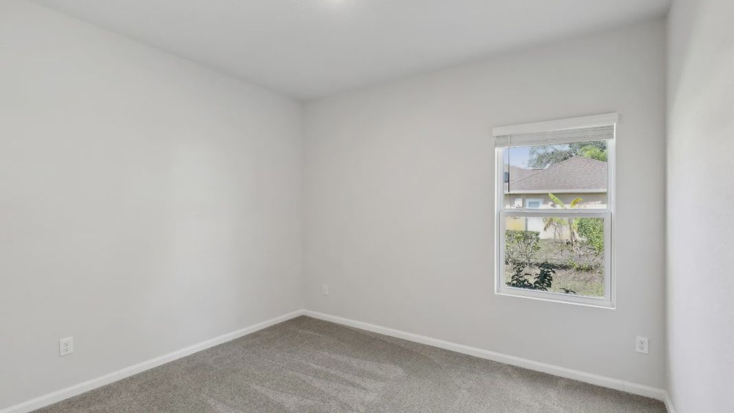 Elegantly simple room featuring plush carpet and large window, offering serene views in Palm Coast.
