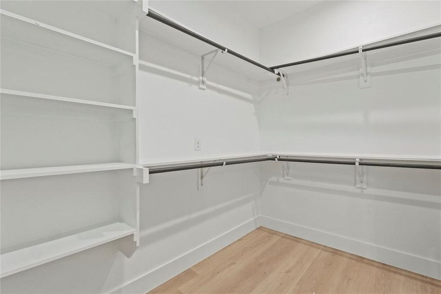 Walk in closet with light wood finished floors Walk in closet with light wood finished floors