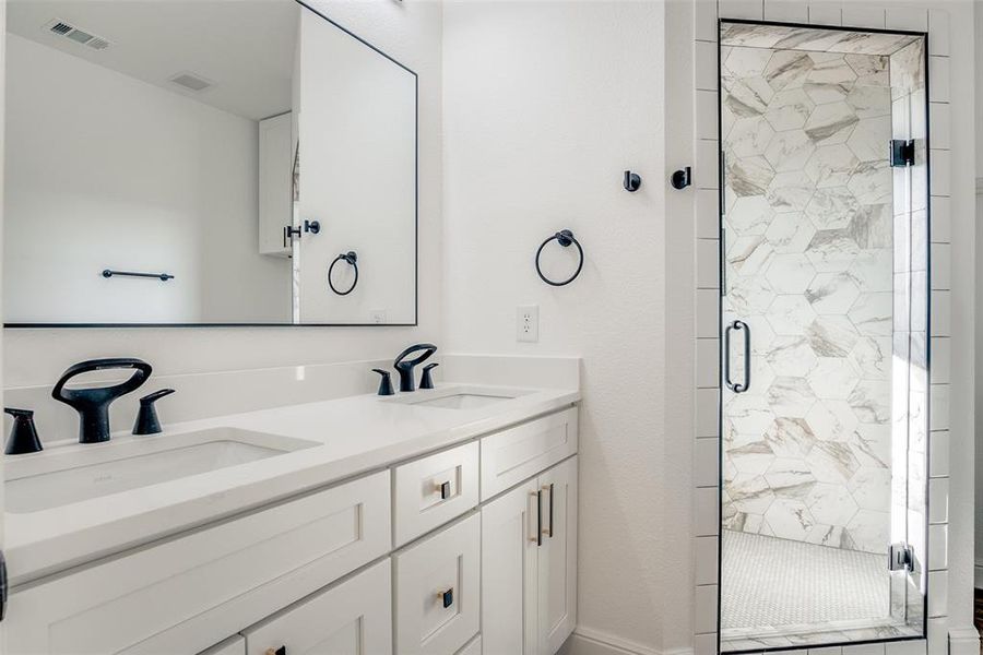 Bathroom with a stall shower and double vanity