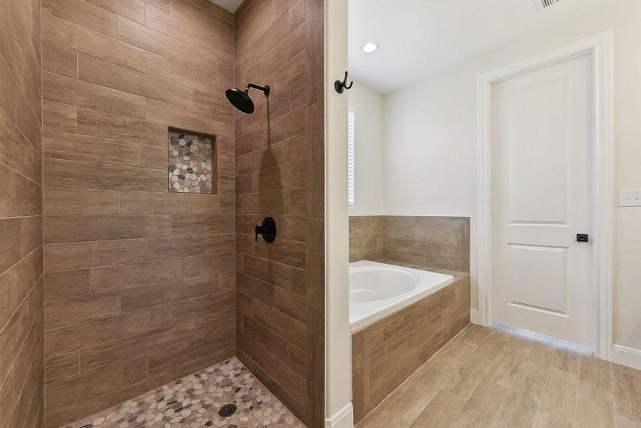 Bathroom featuring a bath and a tile shower Bathroom featuring a bath and a tile shower