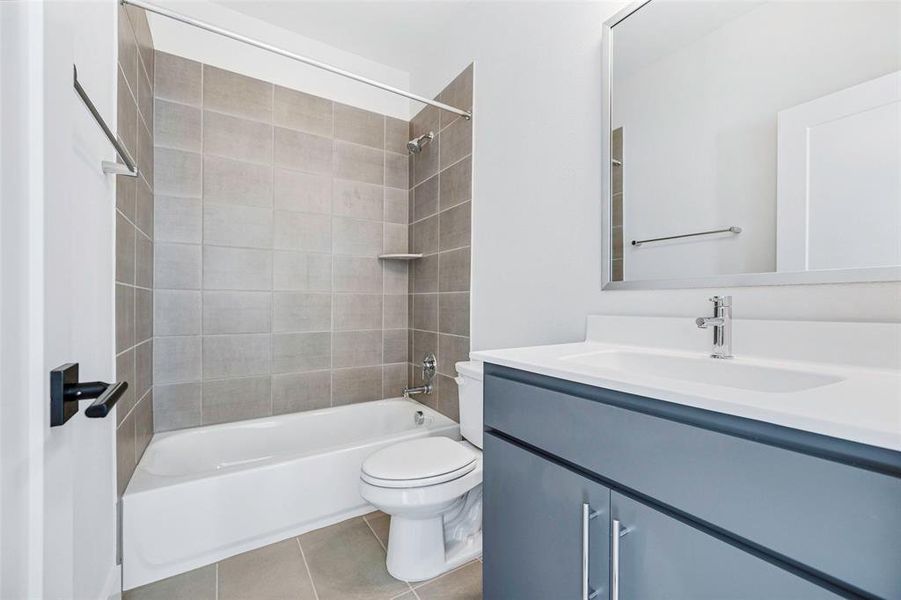 Full bathroom with shower / bathing tub combination, vanity, toilet, and tile patterned floors