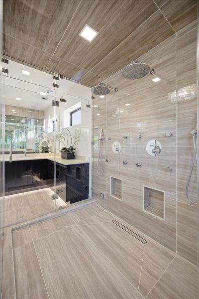 A dual-entry, oversized shower features multiple shower heads and body sprays, delivering a true spa-level experience at home.