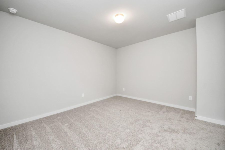 Secondary bedroom features plush carpeting, large windows that let in plenty of natural light, bright paint, and spacious closets. Sample photo of completed home with similar floor plan. Actual colors and selections may vary.