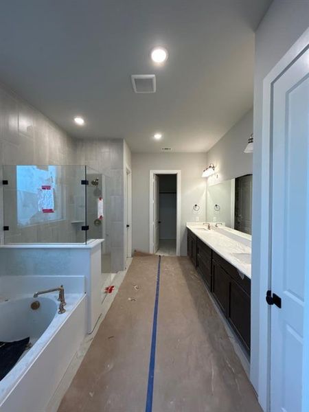 Full bath with a shower stall, a garden tub, double vanity, and recessed lighting