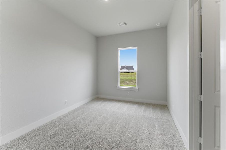 Carpeted interior room with white walls, baseboards, and ceiling