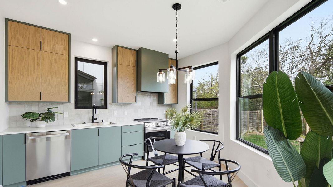 Kitchen with stainless steel appliances, tasteful backsplash, light wood-type flooring, hanging lights, and light stone counters