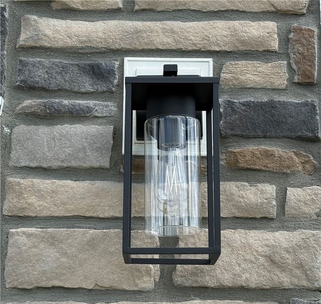 A modern outdoor light fixture illuminates a textu A modern outdoor light fixture illuminates a textu