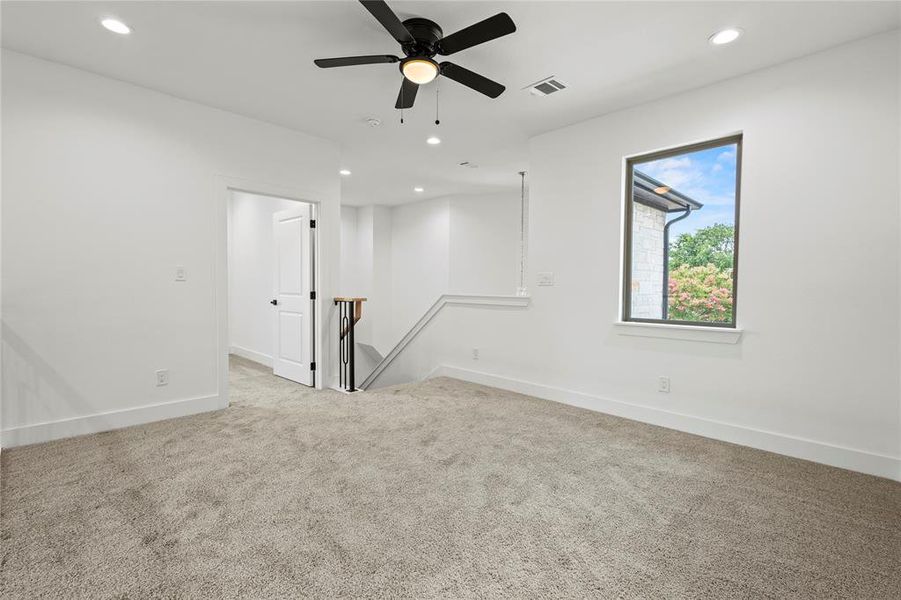 Carpeted spare room with ceiling fan