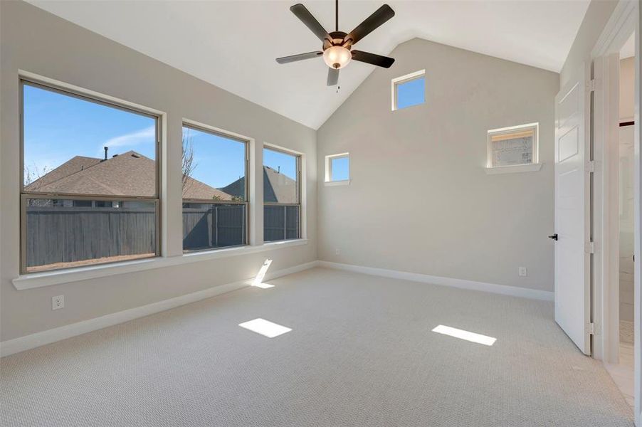Spare room featuring light carpet, a ceiling fan, and a high ceiling Spare room featuring light carpet, a ceiling fan, and a high ceiling