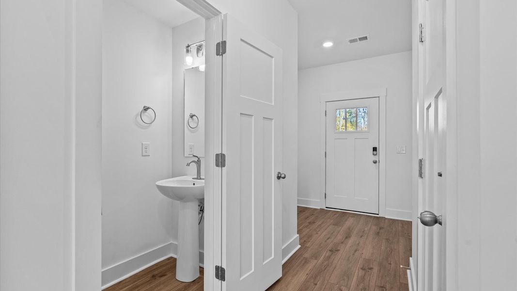 Memorable arrival experience with hardwood floors and elegant trim in the foyer