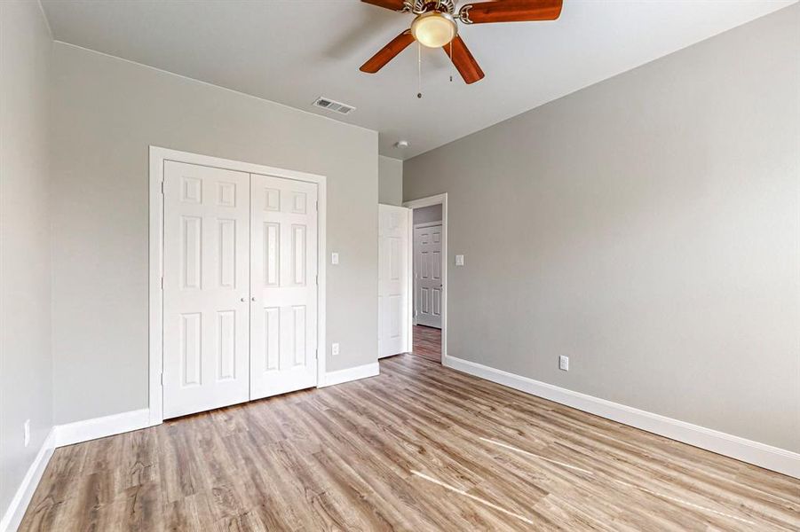 Unfurnished bedroom with ceiling fan, a closet, and light hardwood / wood-style floors