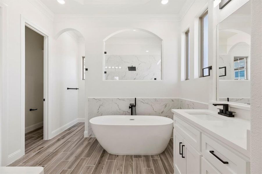 Master Bathroom with separate vanities, independent shower and bath, ornamental molding, and a healthy amount of sunlight