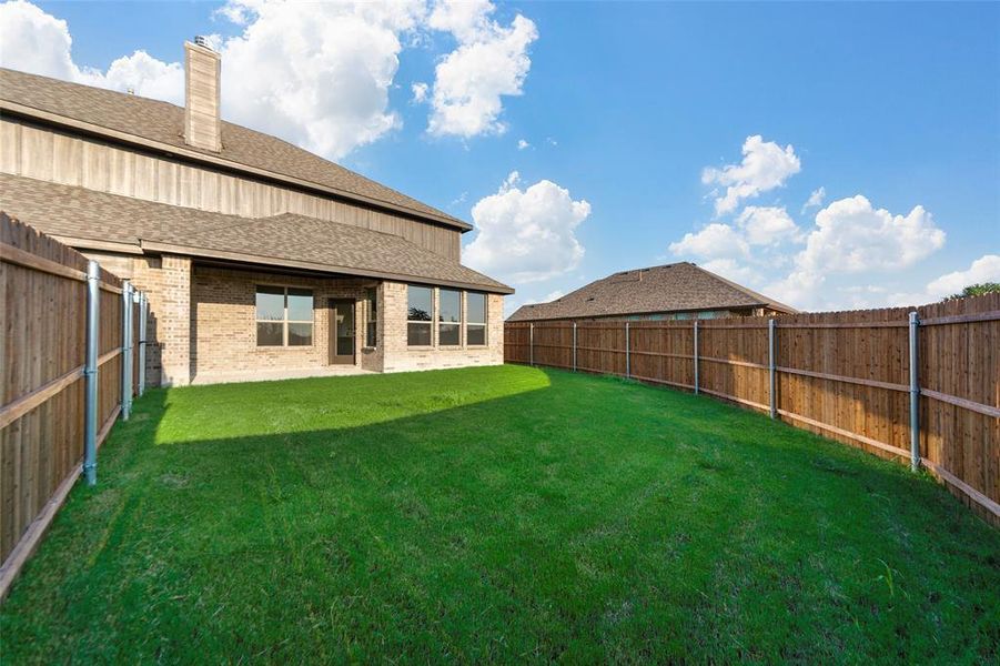 Rear view of property with roof with shingles, brick siding, a patio, a chimney, and a fenced backyard Rear view of property with roof with shingles, brick siding, a patio, a chimney, and a fenced backyard