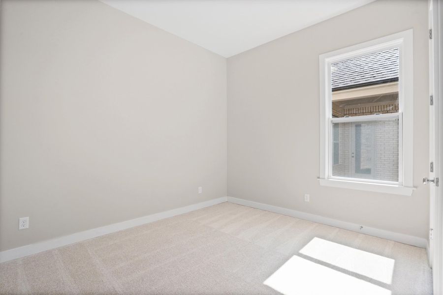 Spare room featuring light carpet and baseboards
