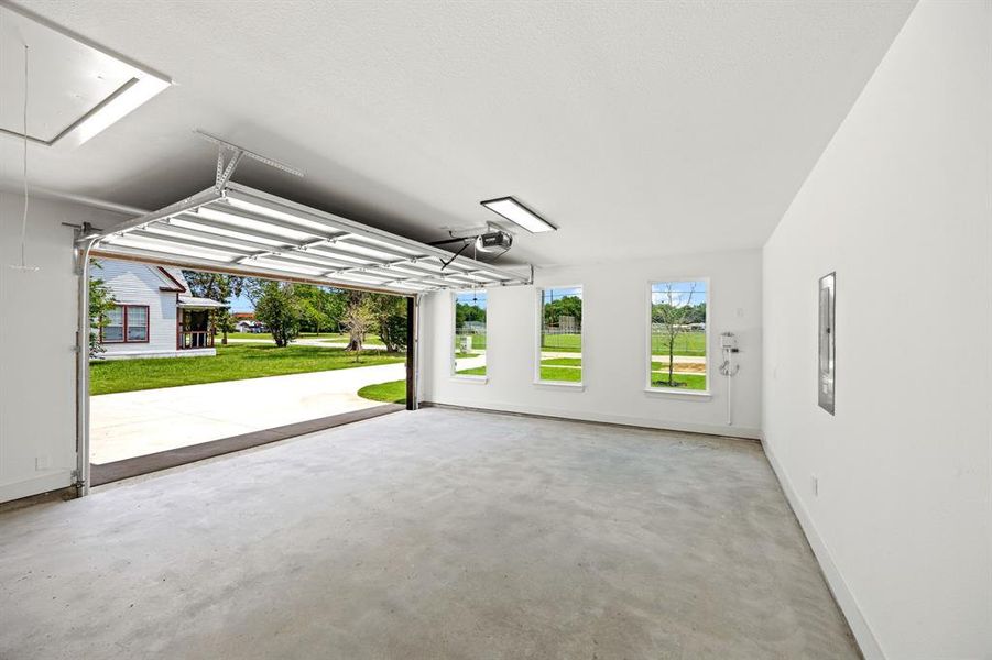 Garage featuring baseboards and a garage door opener Garage featuring baseboards and a garage door opener