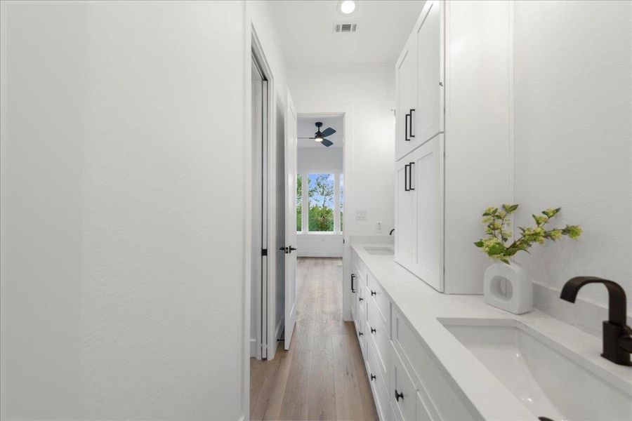 Bathroom with double vanity and wood finished floors Bathroom with double vanity and wood finished floors
