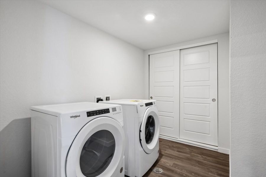 A white washing machine in a room. A white washing machine in a room.